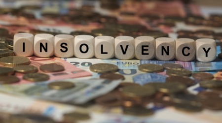 How does an accountant spot potential signs of client insolvency?