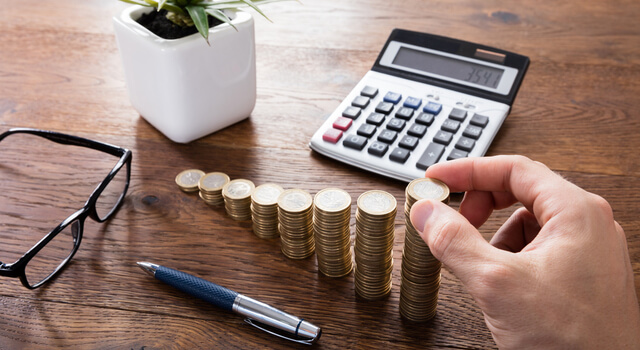 A stack of coins and calculator